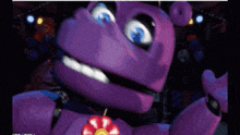 a purple stuffed animal with blue eyes and a flower in its mouth .