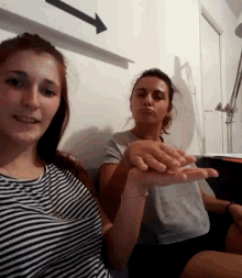 two women are sitting next to each other holding hands