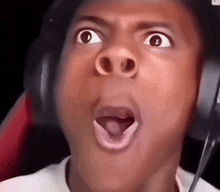 a young boy wearing headphones is making a funny face .