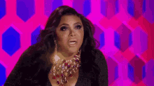 a woman wearing a green dress and a necklace is making a funny face .