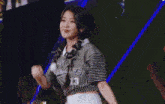 a woman wearing a striped shirt and a braided ponytail is smiling on a stage .