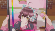 a person is holding a tablet with a picture of a girl wearing cat ears on it