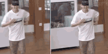 a man in a white shirt is dancing in a room with a fish tank in the background .