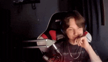 a young man wearing headphones and a microphone is sitting in a chair .