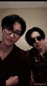 two men wearing glasses and sunglasses are posing for a picture together .