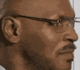 a man wearing glasses and a mustache is making a funny face .