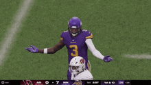 a football player wearing a purple jersey with the number 3 pointing