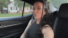 a woman sitting in the back seat of a car