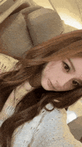 a woman with long brown hair is taking a selfie with her eyes closed