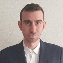 a man in a suit and white shirt is smiling for a picture .