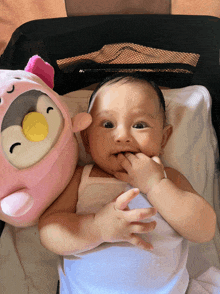 a baby laying in a crib next to a stuffed animal
