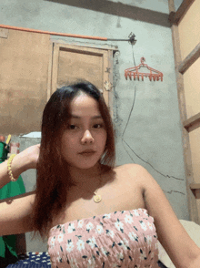 a woman in a strapless top is standing in front of a clothes hanger that says " wat "