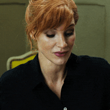 a close up of a woman 's face with red hair
