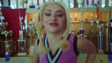 a cheerleader in front of a wall of trophies and medals
