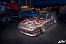a car with the hood open and the words drifted on the bottom right