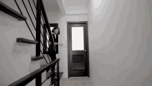 a woman is walking down a set of stairs with a door behind her