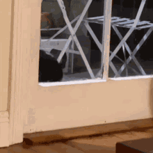 a black cat is looking out of a sliding glass door .