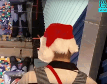 a man wearing a santa hat is standing in front of a vlive logo