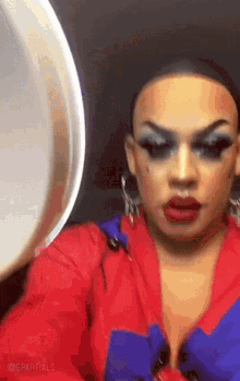 a drag queen is taking a picture of herself in front of a mirror with the hashtag @gpartials