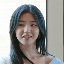 a woman with blue hair looks at the camera and smiles