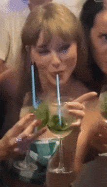 a woman drinking through a straw from a glass