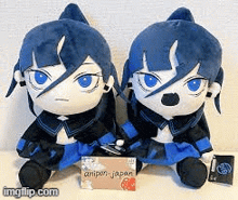 two stuffed animals with blue hair and blue eyes are sitting next to each other on a table .