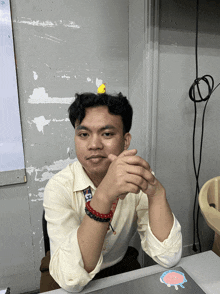 a man with a yellow duck on his head has a sticker on his desk that says ' a ' on it