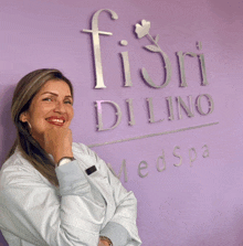 a woman stands in front of a fiori dilino medspa sign