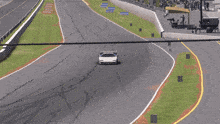 a white sports car is driving down a track