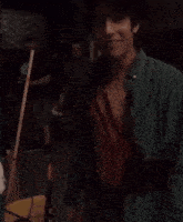 a man in a green shirt has blood on his shirt and is being helped by another man