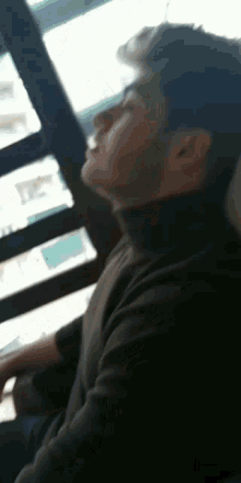 a man in a black turtleneck is looking up