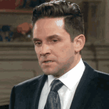 a man in a suit and tie is looking at the camera