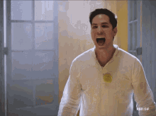 a man in a white shirt has a yellow badge on his chest that says ' rbd.gif '