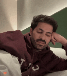 a man with a beard wearing a sweatshirt that says t on it