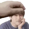 a hand is touching a man 's forehead with its finger .