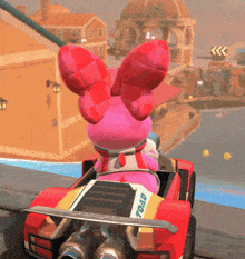a pink bunny is driving a red car with the word toad on the side