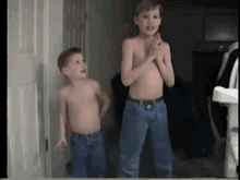 two young boys standing next to each other without shirts