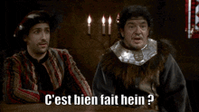 two men are sitting at a table with candles and one of them is saying c'est bien fait hein