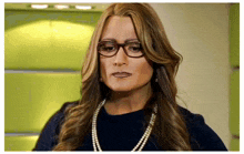 a woman wearing glasses and a pearl necklace is making a funny face
