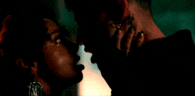 a man with a tattoo on his neck kisses a woman who is crying