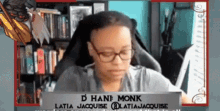 a woman wearing glasses is sitting in front of a laptop with the name d han monk written on it