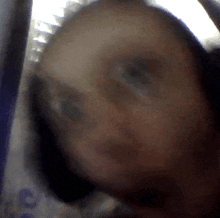 a blurry picture of a person 's face with a few letters visible