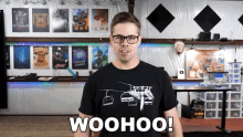 a man wearing glasses and a woohoo t-shirt