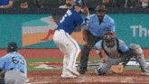 a blue jays baseball player is swinging at a ball