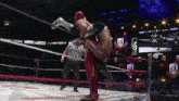 a wrestling match is being held in a ring with a referee .