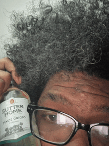 a man holds a bottle of butter home pinot grigio in front of his face