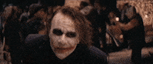 the joker is wearing a suit and tie and making a funny face