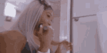 a woman is applying makeup in front of a mirror in the bathroom .