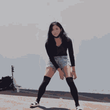 a woman wearing knee high socks and shorts is dancing