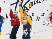 a group of women are dancing in front of a wall that has the word france written on it